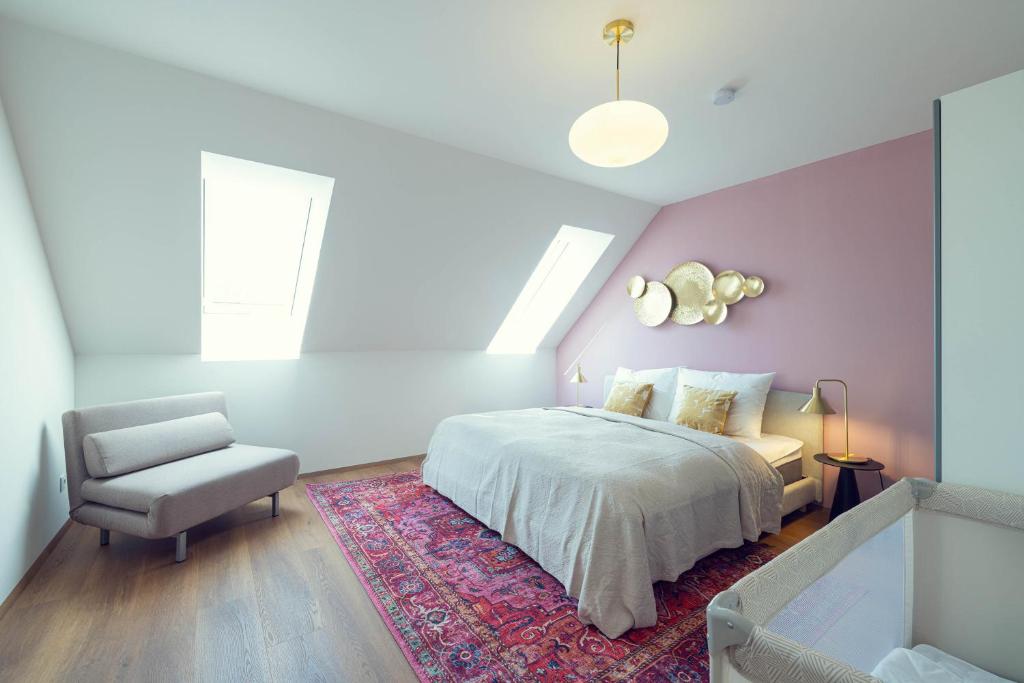 a bedroom with a bed and a chair at LeonArt Living 51 in Graz