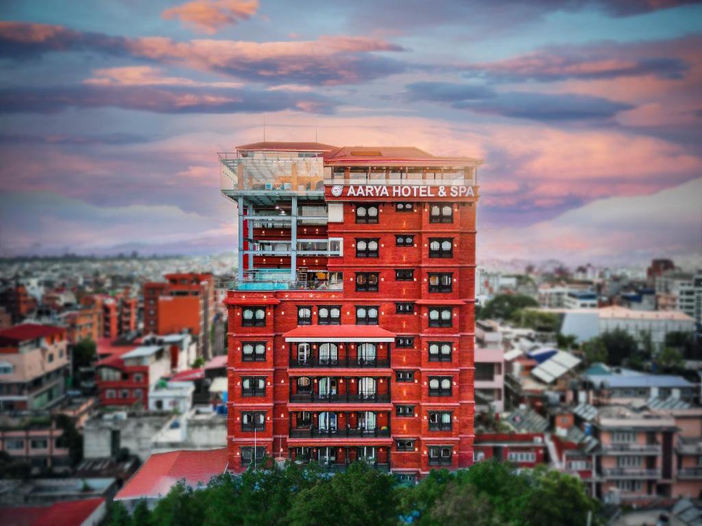 Un edificio alto de ladrillo rojo con un cartel. en Aarya Hotel and Spa - Eternal Heritage, en Katmandú