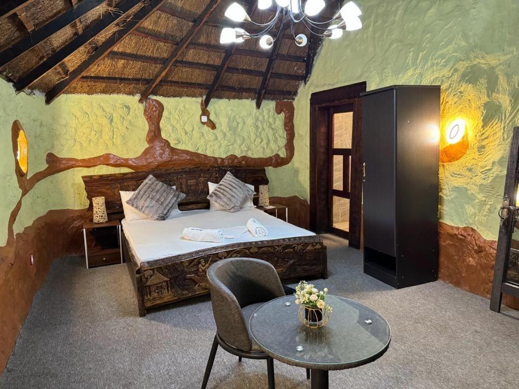 een slaapkamer met een bed en een tafel in een kamer bij Ferme hasna in Lubumbashi