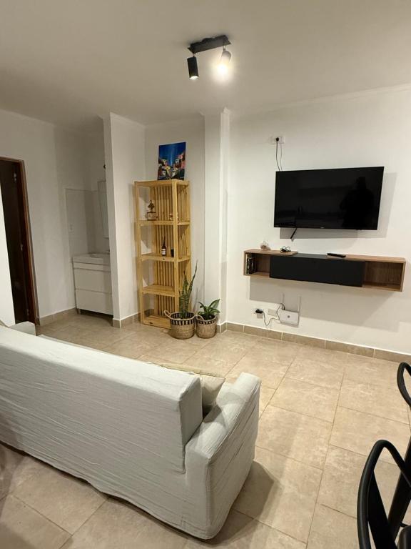a living room with a white couch and a flat screen tv at Depto 25 de mayo in Viedma
