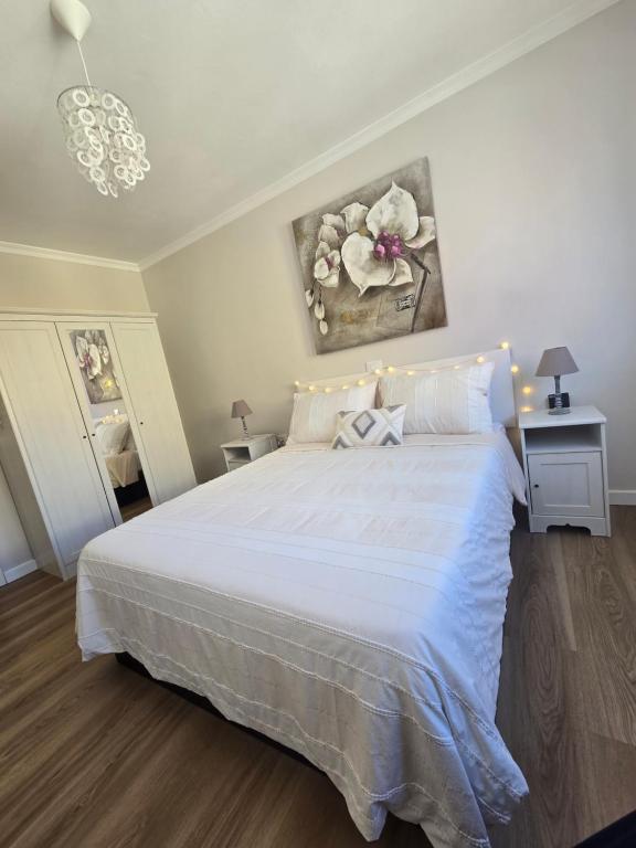 Un dormitorio con una gran cama blanca en una habitación. en El Rincón de Nicolás, en Arinaga