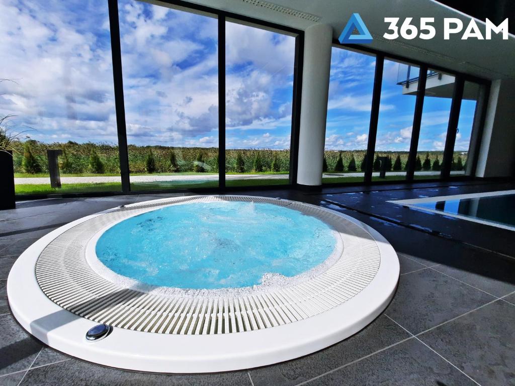 Una gran piscina en un edificio con ventanas. en Westin House Rodzinny z 2 sypialniami - BASEN, JACUZZI, SAUNA, SALA FITNESS, PLAC ZABAW, PARKING W CENIE - 365PAM, en Kołobrzeg