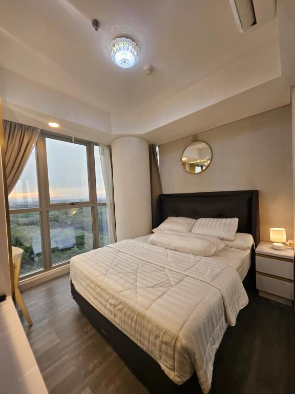 a bedroom with a large bed and a large window at Apartemen Oakwood honolulu in Jakarta