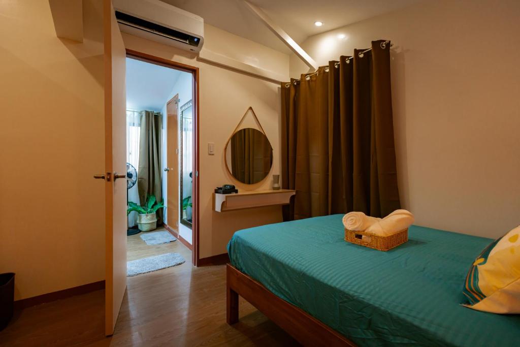 a bedroom with a green bed and a mirror at Upper Bliss Homestay in El Nido
