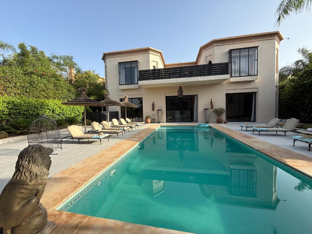 a house with a swimming pool in front of a house at Villa Jude Luxury 6BR Villa with Private Pool, Sleeps 12, Near Golf & City in Marrakesh