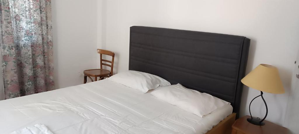 una camera con letto bianco e testiera nera di Chris's house in Spetses a Spetses