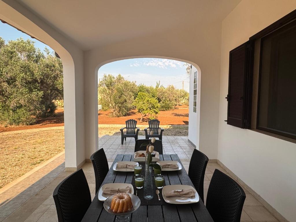 a dining room with a table and chairs and a window at Villetta Aleanna in Serranova