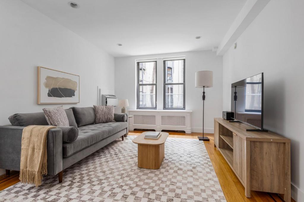 Una sala de estar con un sofá y un televisor de pantalla plana. en Blueground Lincoln Sq gym wd nr park NYC-1849, en Nueva York