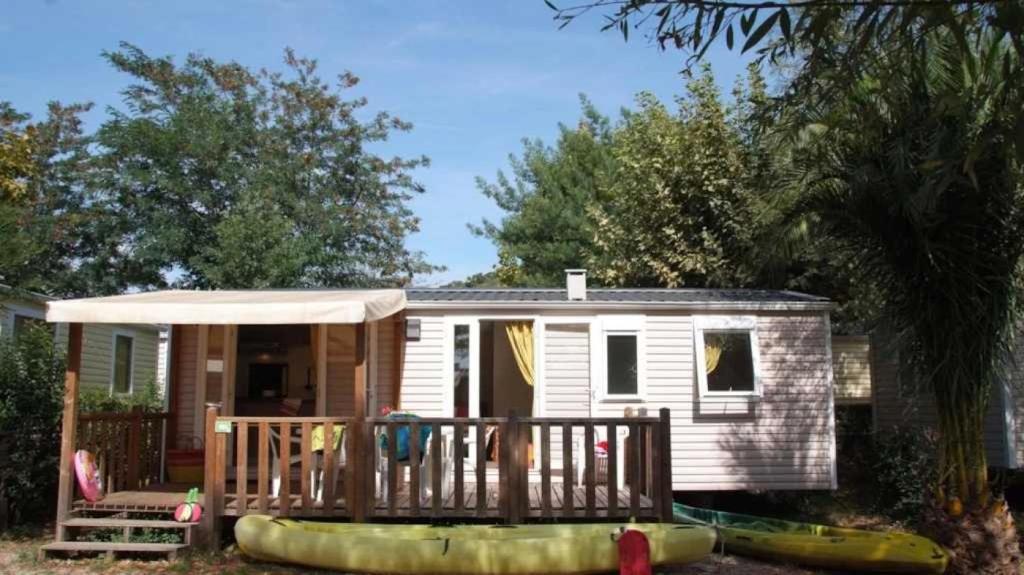 une petite maison avec un porche et une terrasse dans l'établissement Camping 4 étoiles - Parc aquatique - eec0ef, à Agay