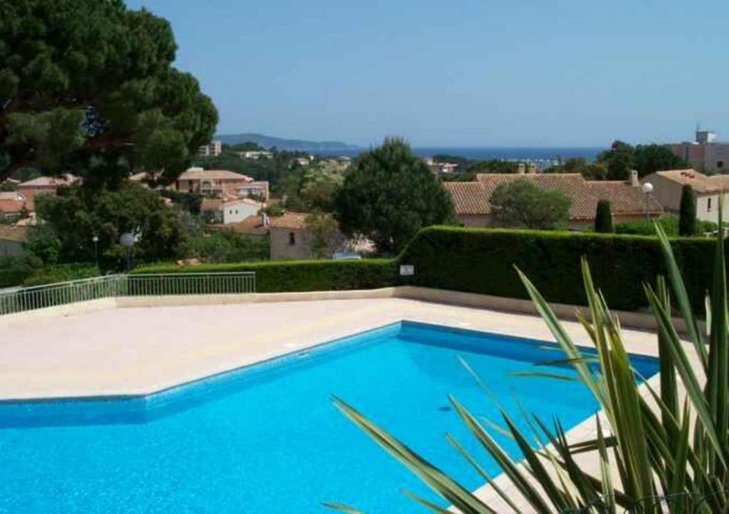 - une piscine bleue avec vue sur la ville dans l'établissement Studio Mezzanine 4 personnes PISCINE VUE MER, à Cavalaire-sur-Mer