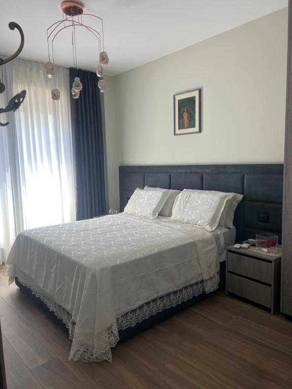 a bedroom with a large bed and a chandelier at Halisof TEG residenziale 