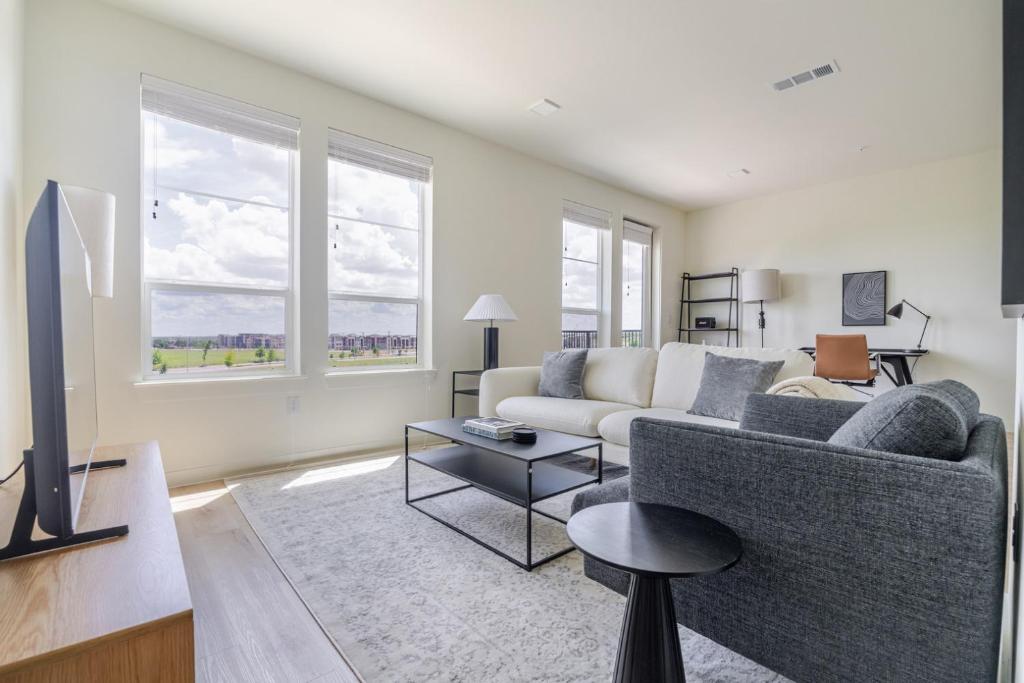 a living room with a couch and a tv at Blueground Round Rock pool nr Old Settlers Park ATX-327 in Austin