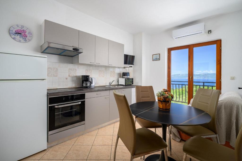 a kitchen with a table and a table and chairs at Ferienwohnung 5235-3 in Drenje in Drenje