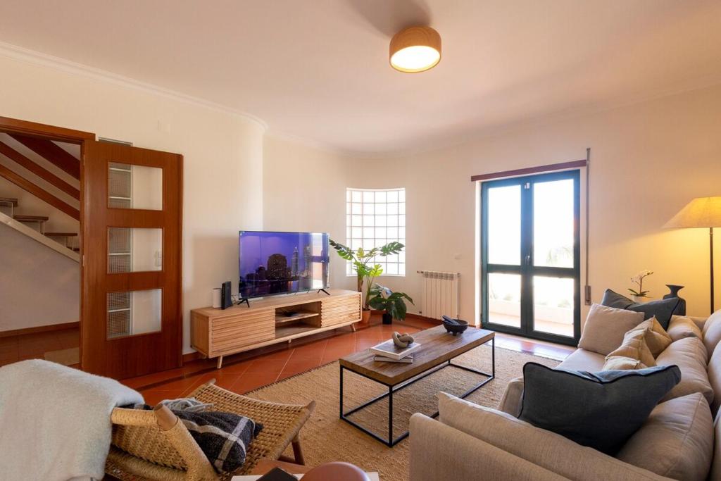 a living room with a couch and a flat screen tv at Wave Song Villa in Santo Isidoro