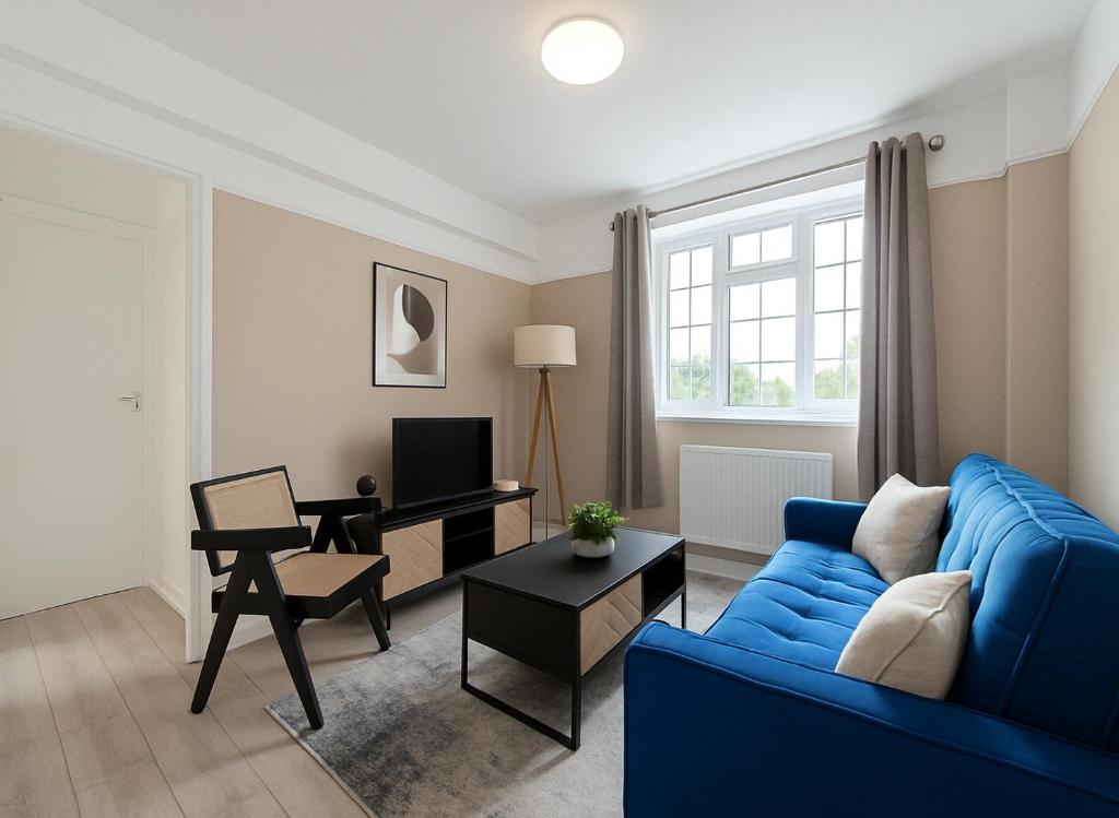 a living room with a blue couch and a desk at Spacious 2-Bedroom Apartment in Crystal Palace in London