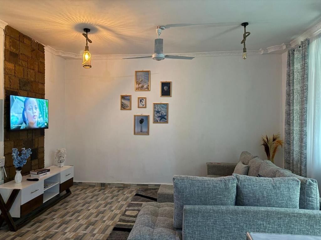 a living room with a couch and a tv at Aligna Bamburi in Mombasa