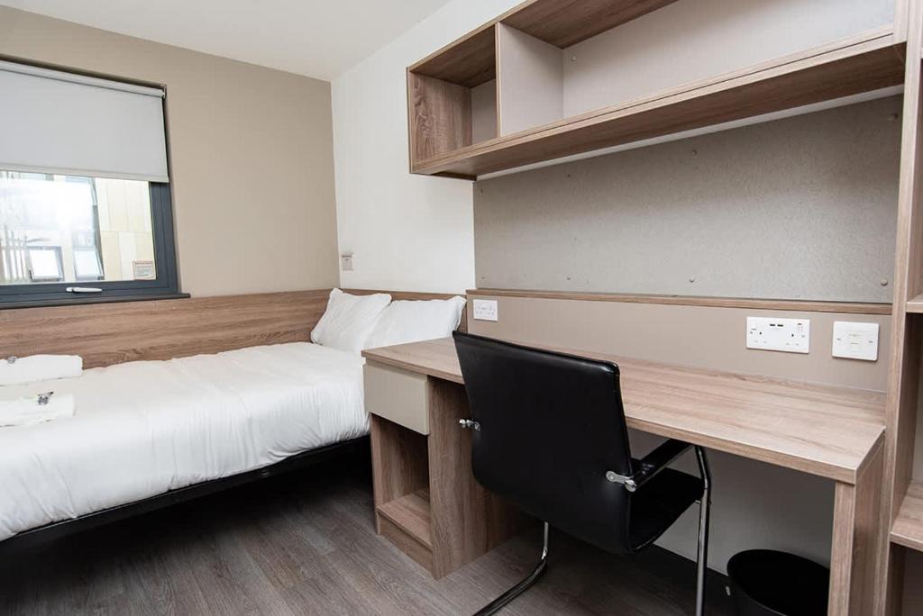 a bedroom with a bed and a desk with a desk at Ensuite Single Room in Central Coventry in Coventry