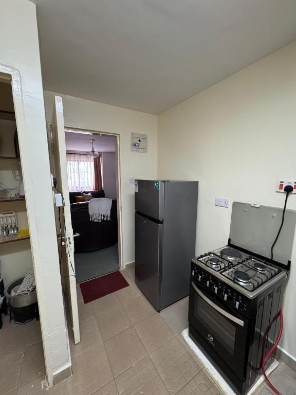 una cocina con estufa y refrigerador en Nyayo Estate Embakasi near Airport and Sgr, en Nairobi