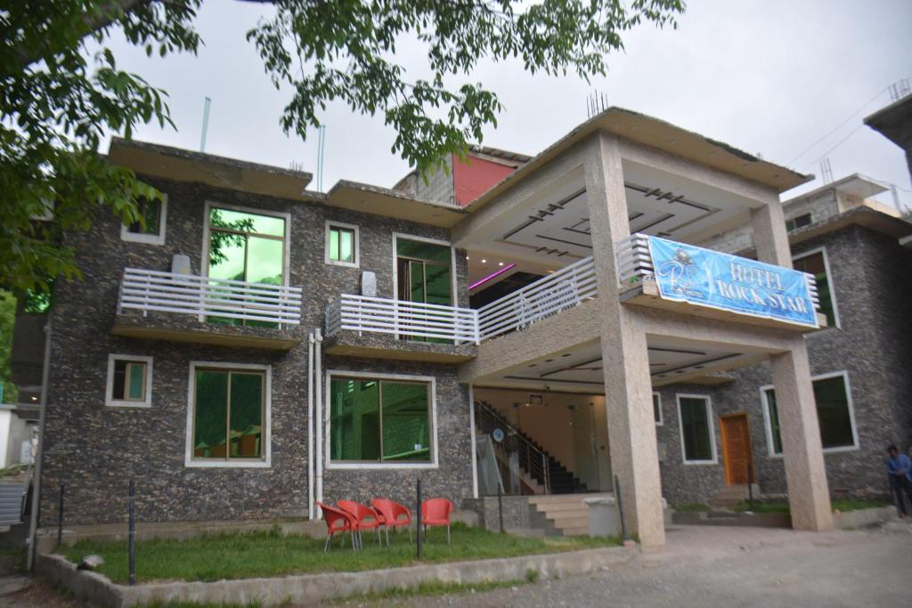 a building with red chairs in front of it at Hotel Rock Star, Naran in Naran