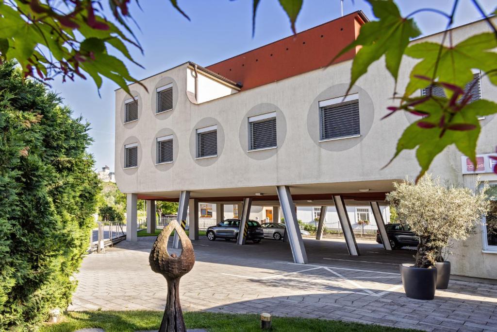 a building with a car parked in a parking lot at Penzion Royal in Trenčín