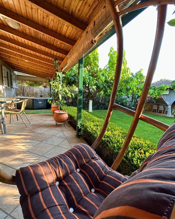 Eine Couch auf einer Terrasse mit Holzdach in der Unterkunft The Βeach - Family House in Amaliada