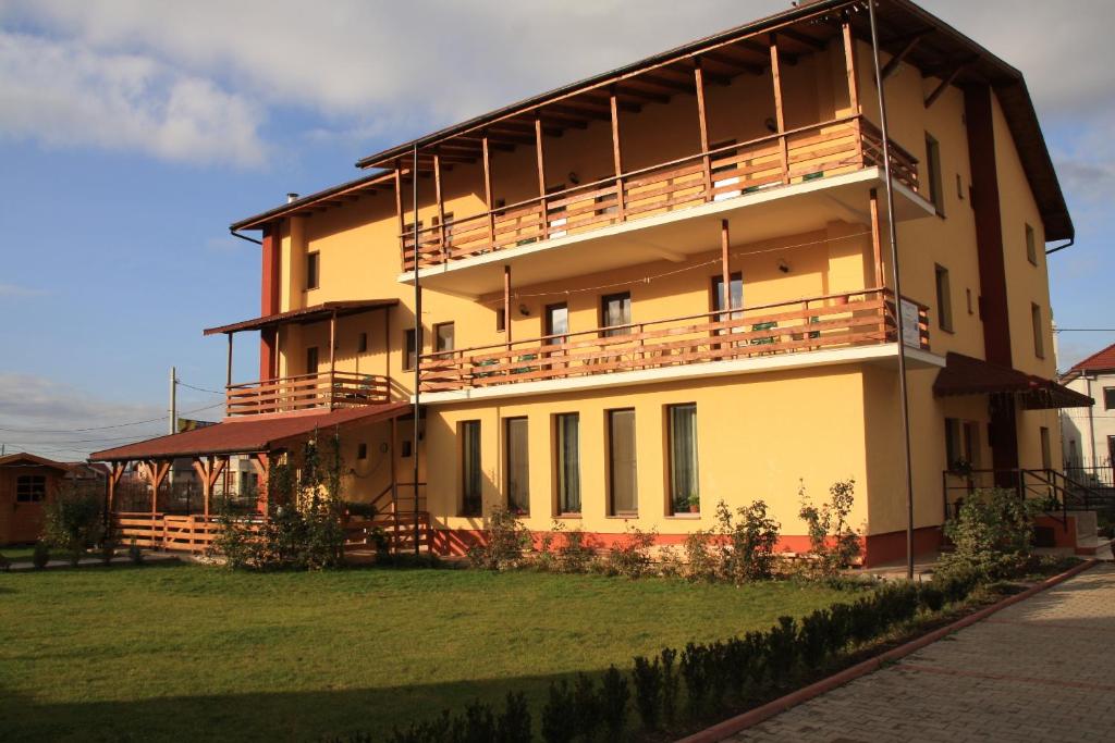 a large building with balconies on the side of it at Pensiunea Maria , Floresti in Floreşti