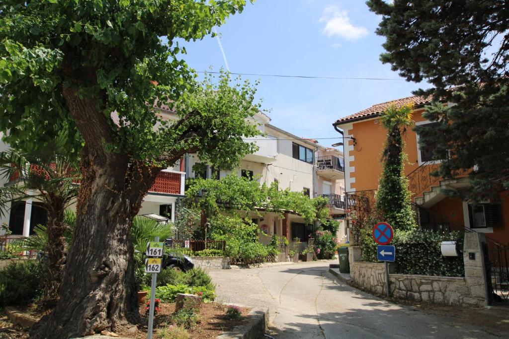 une rue dans une ville avec un arbre et des bâtiments dans l'établissement Apartments Sonnenblume, à Funtana