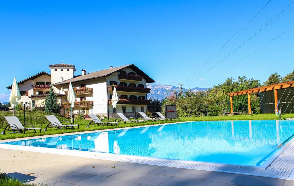 a large swimming pool in front of a building at Hotel Brückenwirt - Al Ponte in Montagna