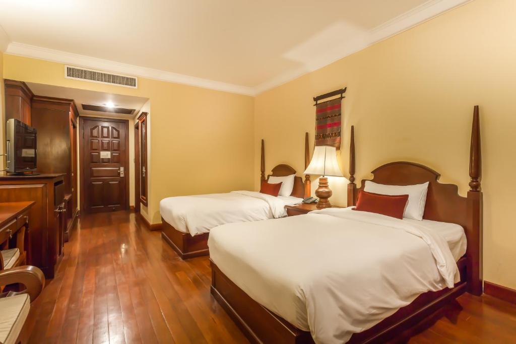 a hotel room with two beds and a television at Prince Angkor Hotel & Spa in Siem Reap