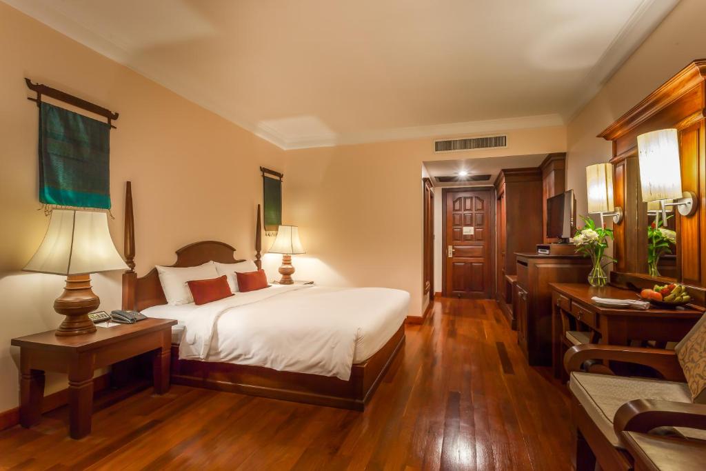 a bedroom with a bed and a table and a desk at Prince Angkor Hotel & Spa in Siem Reap
