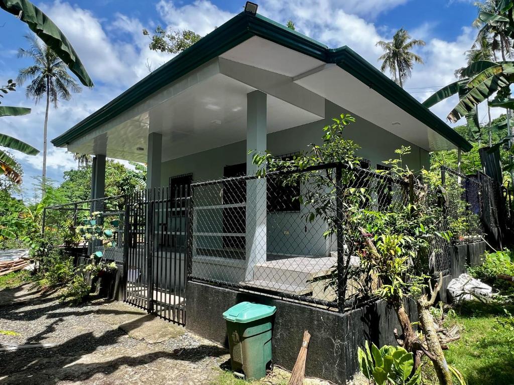 a small house with a gate and a trash can at Publikhaus in Caliclic