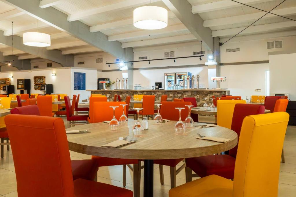 a dining room with a wooden table and chairs at Ohtels Carabela in Matalascañas