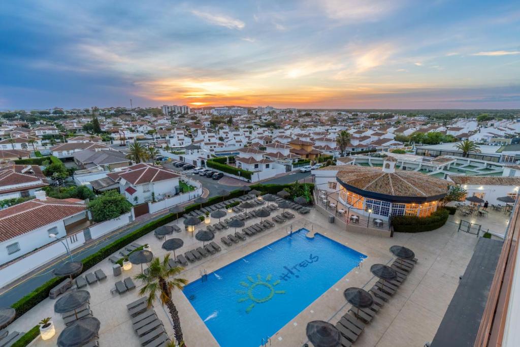 an aerial view of a city with a swimming pool at Ohtels Carabela in Matalascañas