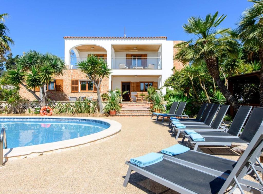a villa with a swimming pool and lounge chairs at Villa Can Cardona Sea views Perfect 4 families in Sant Rafael de Sa Creu