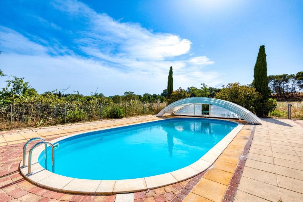 une piscine avec un toit en verre sur une terrasse dans l'établissement Joli Studio Au Bord De La Rivière -, à Aspiran