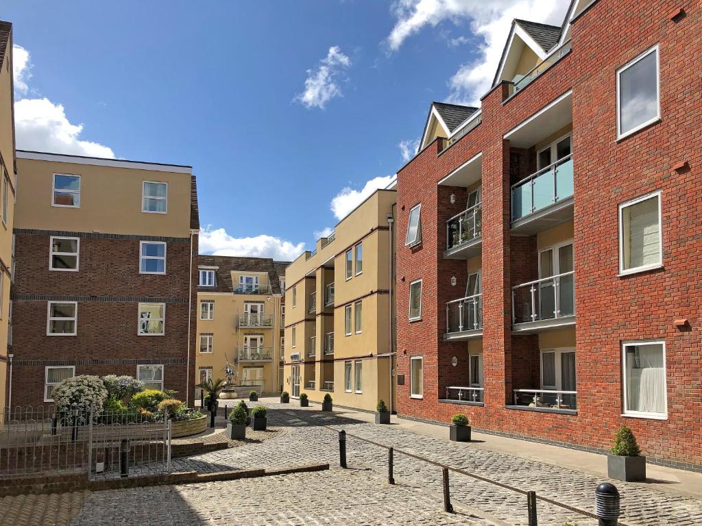 a cobblestone street in front of brick buildings at Chichester City Centre 2 Bedroom Flat I Ground Floor with Underground Parking I Chichester Holiday Properties in Chichester