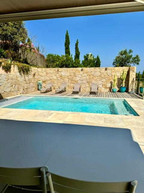 une vue d'une piscine à travers une fenêtre dans l'établissement Somptueuse villa d’architecte avec vue mer, à Belvédère