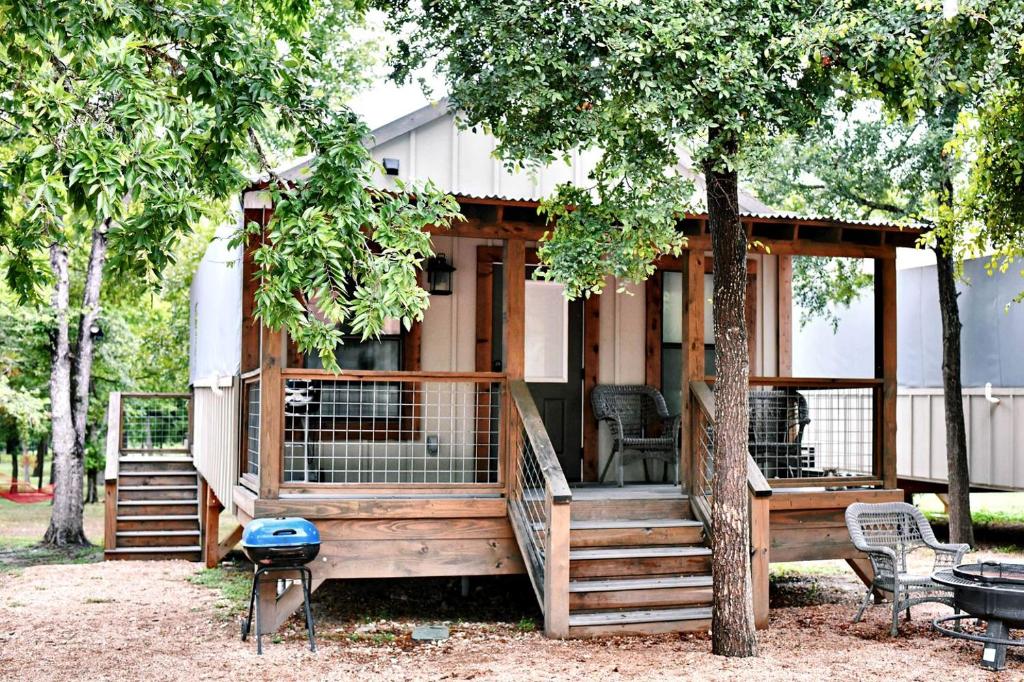 ein großes Holzhaus mit einem Baum in der Unterkunft Beautiful Tented Cabin by a Creek - Ideal for a Fun Family Vacation in Seguin, Texas in Lauback