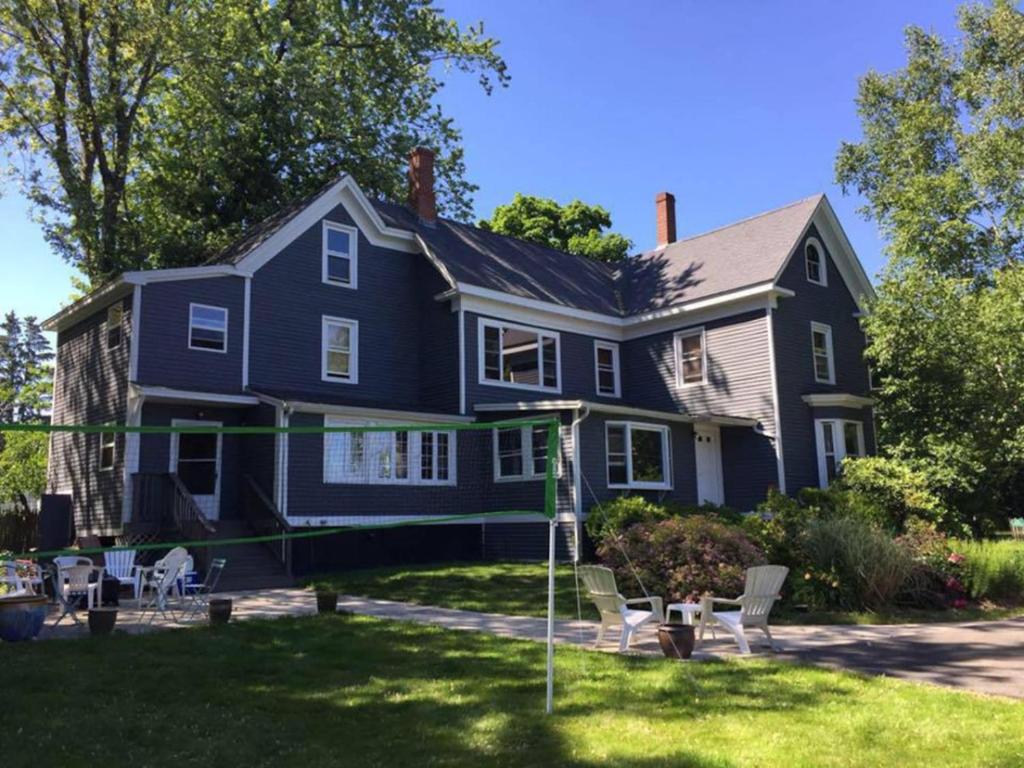 a blue house with chairs in the yard at Back Cove - Large Sunny 2 Bedroom Condo in Portland