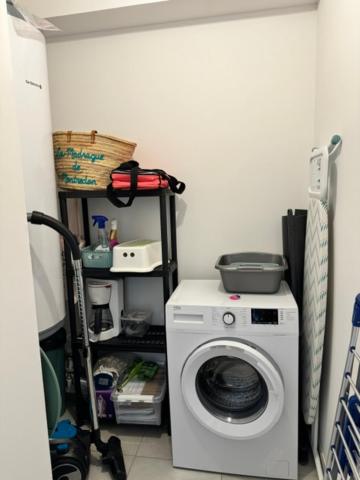 a laundry room with a washing machine and a shelf at Appart tout équipé et vue sur la mer in Propriano