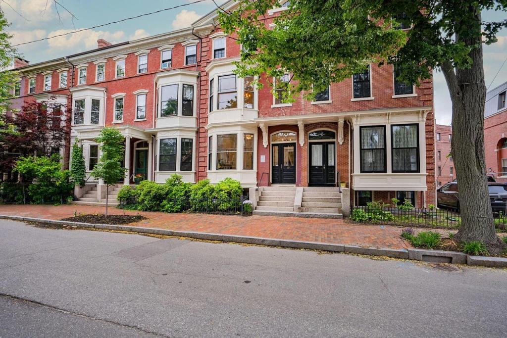 Una gran casa de ladrillo rojo con un árbol en una calle. en Local Landmark - Gorgeous Historic Home, en Portland