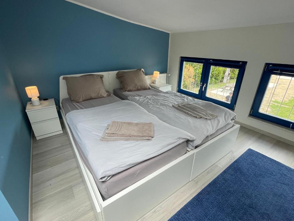 een slaapkamer met een groot bed met een blauwe muur bij Appartements Marina Niderviller in Niderviller