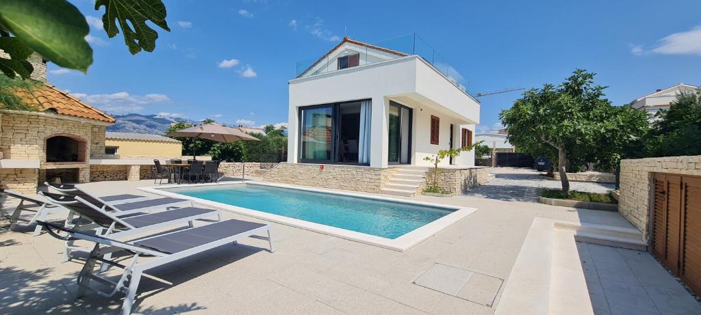 a villa with a swimming pool and a house at Villa Emma - luksuzna kuća s bazenom Wellness & SPA in Ražanac