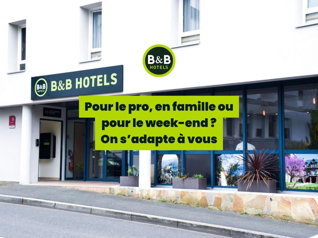 una tienda con un cartel en el costado de un edificio en B&amp;B HOTEL Rodez Bourran, en Rodez