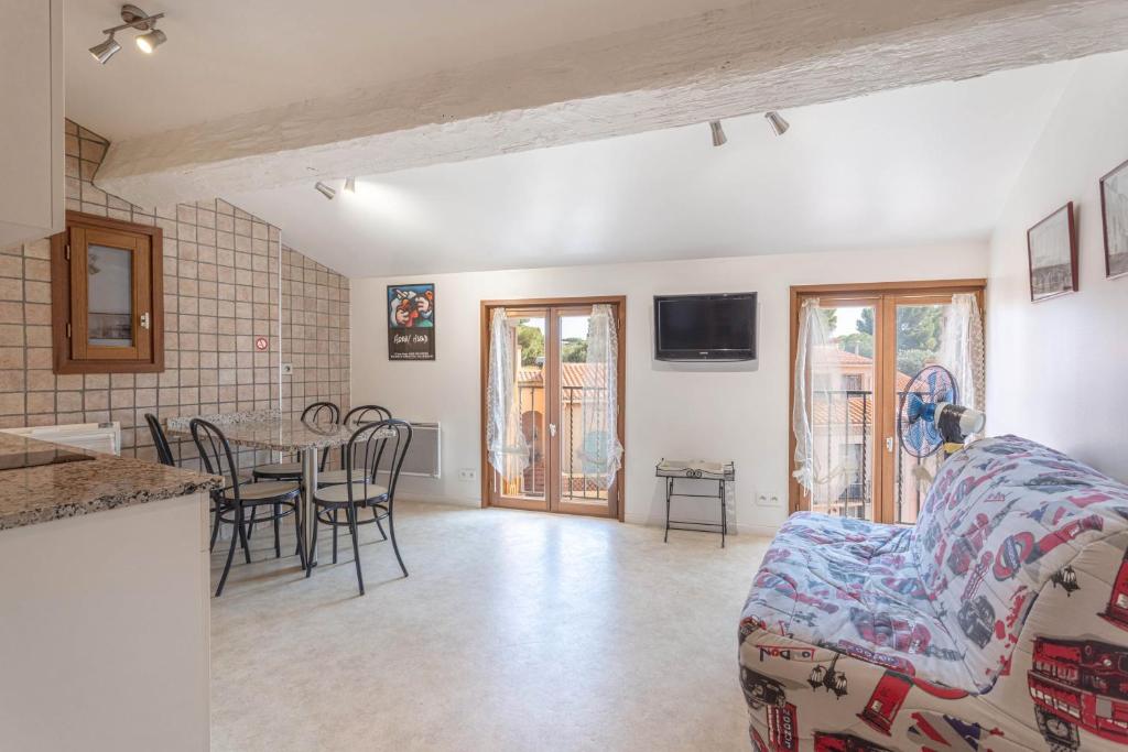 - un salon avec une cuisine et une table avec des chaises dans l'établissement Grand Studio pieds dans l'eau, à Collioure