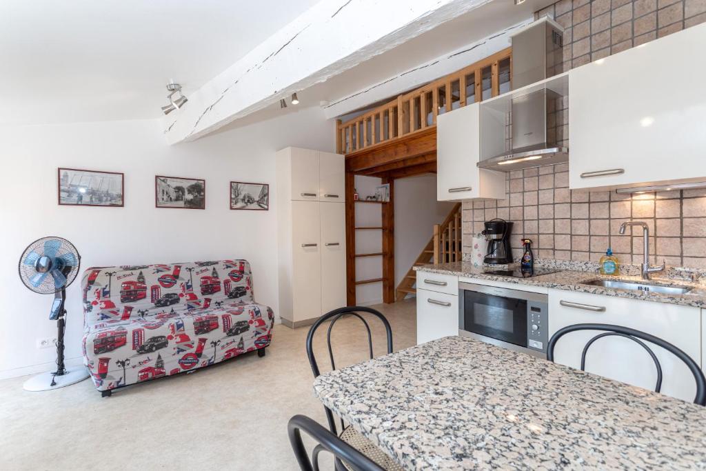 a kitchen with a table and chairs and a couch at Grand Studio pieds dans l'eau in Collioure