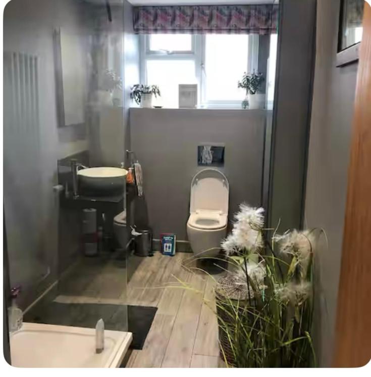 a small bathroom with a toilet and a sink at Commuters Haven perfect for conferences airport and offices near airport in Cove