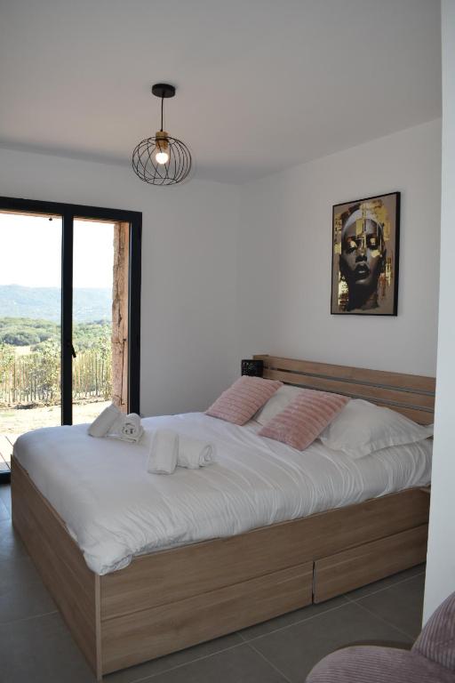 ein großes Bett in einem Zimmer mit Fenster in der Unterkunft Alivu bergerie Sotta hyper cosy in Sotta