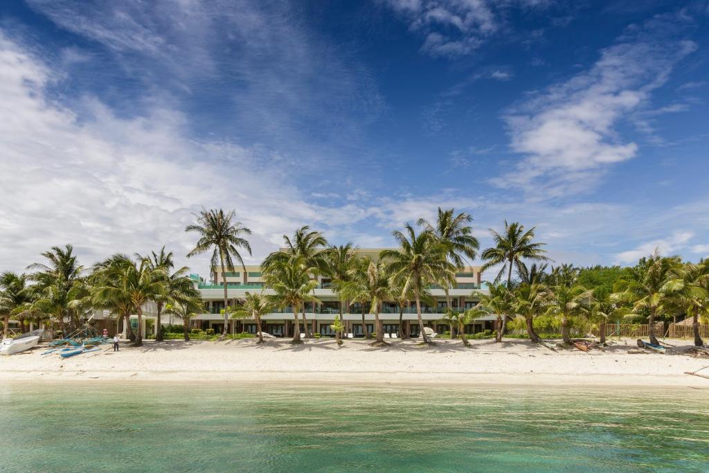 un complejo en una playa con palmeras y agua en Under the Stars Luxury Apartment, en Boracay