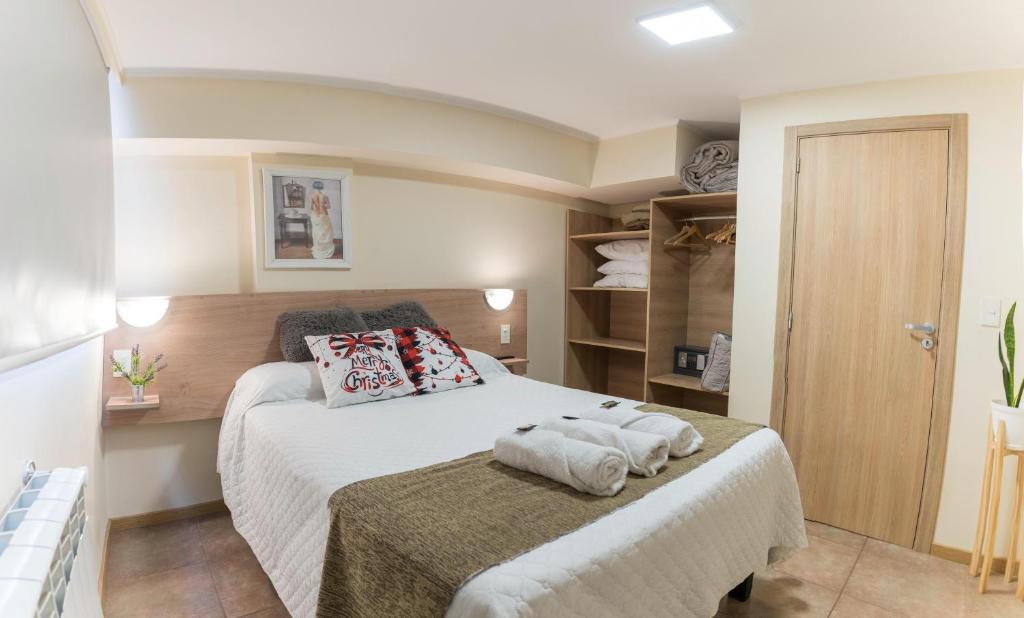 a bedroom with a bed with towels on it at Patagonia suites Bariloche in San Carlos de Bariloche